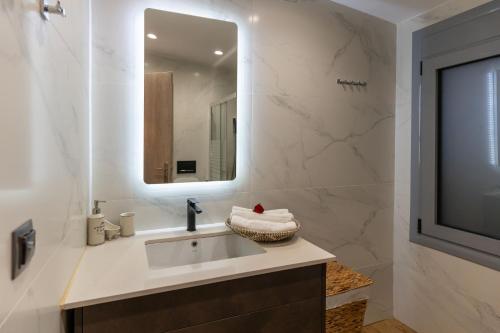 a bathroom with a sink and a mirror at Private Pool Retreat - Georgia's Garden Oasis in Alónia