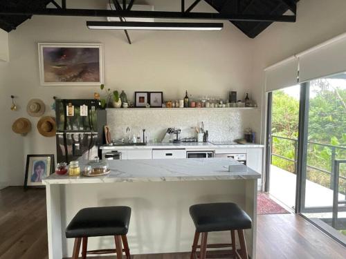 a kitchen with a counter and two stools at Casa Khang - a peaceful cottage close to HCMC in Xã Cam Mỹ