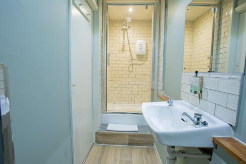 La salle de bains est pourvue d'un lavabo et d'une douche. dans l'établissement The Midland Hotel, à Leeds