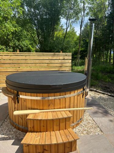 a wooden circle with a black top in a park at Celtic Minor Pods in Ystalyfera