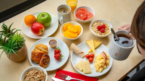 a table with plates of food and bowls of fruit at ibis Paris 17 Clichy-Batignolles in Paris