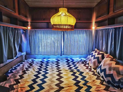 a bedroom with a bed with a lamp and curtains at Caravan of Love by Casa das Artes in Luz de Tavira