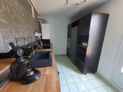 Una cocina con una pared de pizarra negra y un fregadero. en Appartement 6 couchages environnement paisible, en Saint-Étienne-du-Rouvray