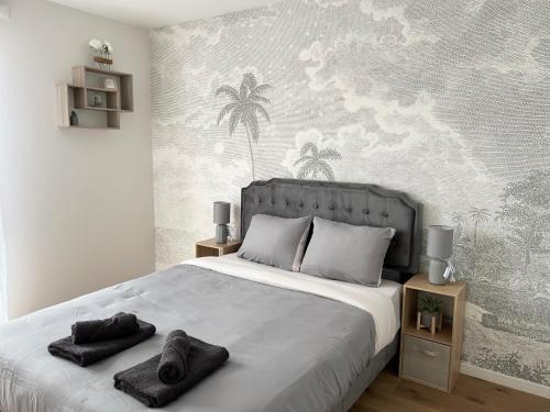 une chambre avec un grand lit avec des serviettes dessus dans l'établissement Majestic Blue- Parking Privé, à Ivry-sur-Seine