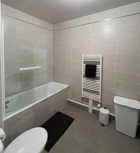 une salle de bain avec une baignoire, des toilettes et un lavabo dans l'établissement Majestic Blue- Parking Privé, à Ivry-sur-Seine