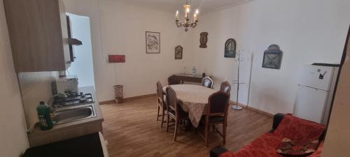 una cucina con tavolo e una cucina con lavandino di room "Al Cristo Velato" a Napoli
