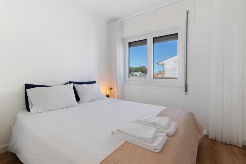 una camera da letto bianca con un letto bianco e una finestra di My Beach House Esposende a Esposende