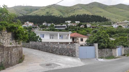 una casa con un muro di pietra e un cancello di Lake view a Shkodër