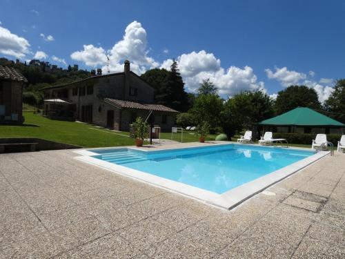 a swimming pool in front of a house at Scappo in Umbria, Casale Piccino in Collicello
