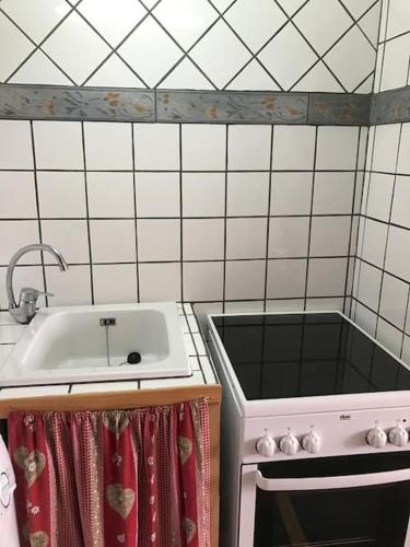 une cuisine avec un évier et une cuisinière dans l'établissement T2 orcières merlette vue montagne, à Orcières