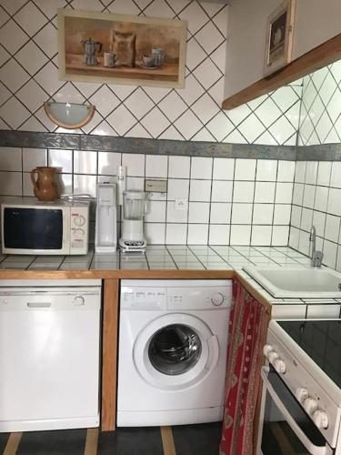 une cuisine avec un lave-linge et un micro-ondes dans l'établissement T2 orcières merlette vue montagne, à Orcières