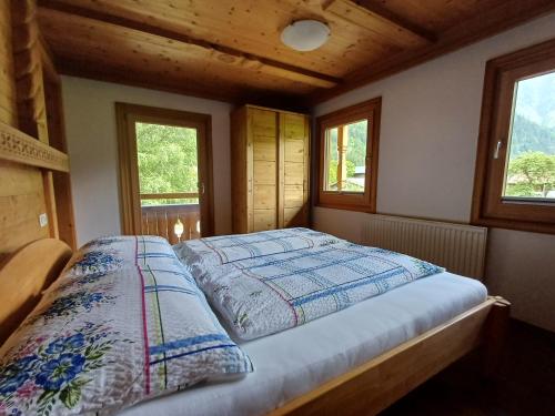 a bedroom with a bed in a room with windows at Landhaus Eberler in Mayrhofen