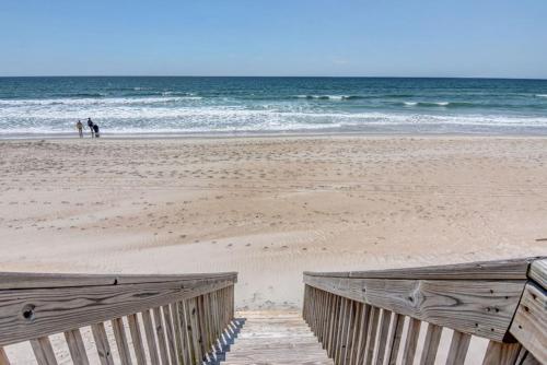 un paseo marítimo de madera en una playa con el océano en Hicks, en Surf City