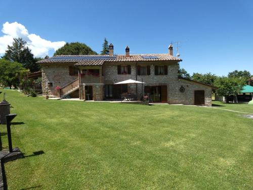 uma grande casa de pedra com um grande quintal em Scappo in Umbria, Casale Piccino em Collicello