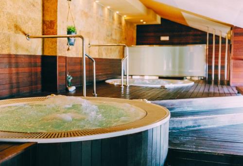 uma casa de banho com banheira de hidromassagem e 2 lavatórios em Hotel Monarque Costa Narejos em Los Alcázares