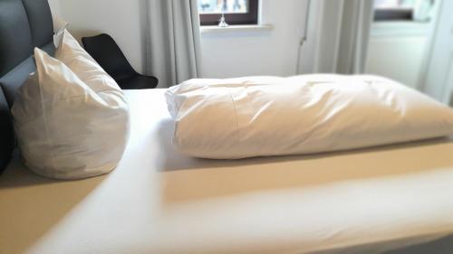 two white pillows sitting on top of a bed at Hotel Schneiderhof in Braunlage