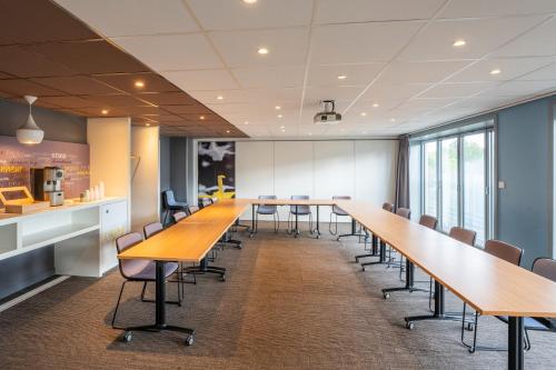 a long conference room with wooden tables and chairs at ibis Paris 17 Clichy-Batignolles in Paris