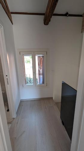 a white room with a window and a wooden floor at Casa Rosabianca in Venice-Lido