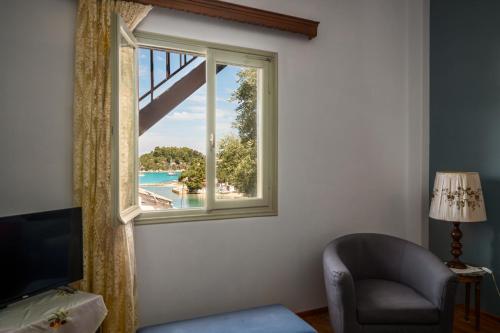 uma janela com uma cadeira e vista para uma piscina em Agaloula Centrally Located Apartments by Konnect, Lakka em Lákka