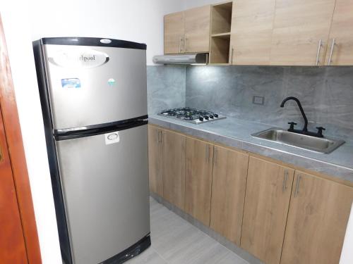 a kitchen with a refrigerator and a sink at El Velero Apartamentos By DANP in Santa Marta