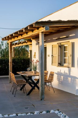 a patio with a wooden pergola and a table and chairs at Naxos Finest Hotel & Villas in Naxos Chora