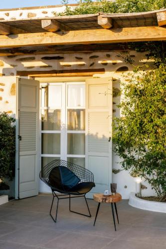 a chair on a patio under a pergola at Naxos Finest Hotel & Villas in Naxos Chora