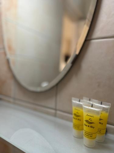 Zwei Tassen stehen auf einer Theke vor einem Spiegel. in der Unterkunft Dafnes Rooms in Fourka