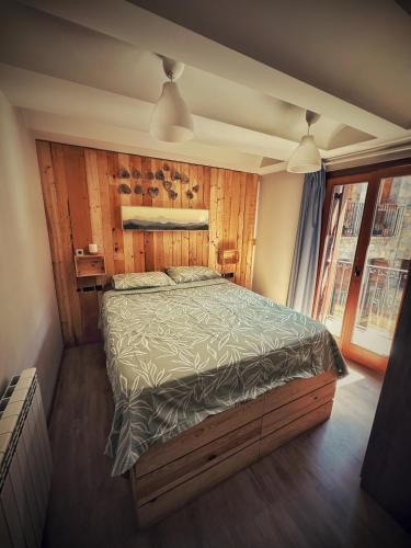 a bedroom with a bed with a wooden wall at La casa Pedalejo in Benasque