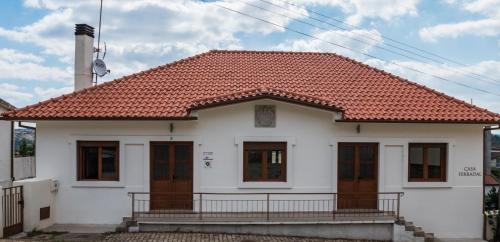 a white house with a red roof at Casa Ferradal in Quintanilha
