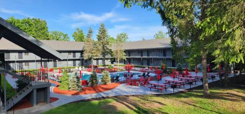 a building with a pool with red chairs and tables at The Stone Gate Resort in Lake George