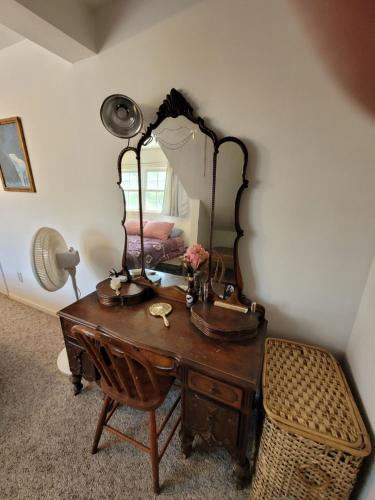 a dressing table with a mirror and a chair at Oscoda Hilltop Haven - Great Location Near Beach! in Oscoda