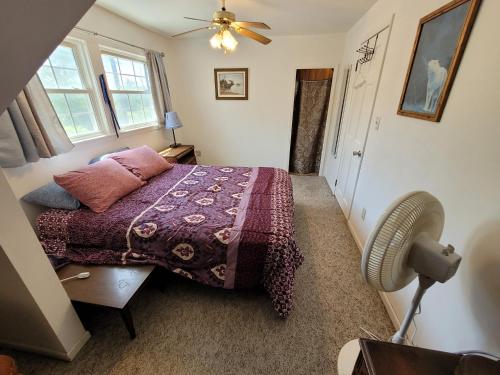a bedroom with a bed and a fan at Oscoda Hilltop Haven - Great Location Near Beach! in Oscoda