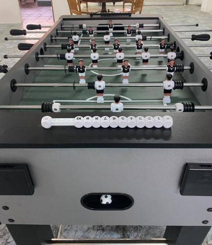 a pool table with people on top of it at Tranquil Mansion - 3 Bed, Pool, BBQ & Gaming Room in Is-Swieqi