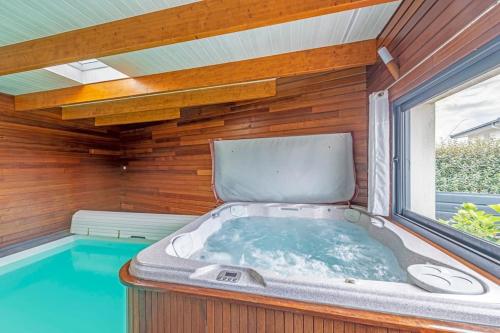 une baignoire jacuzzi dans une chambre avec fenêtre dans l'établissement Rêve d'Océan Villa vue mer avec Piscine et Spa, au Conquet