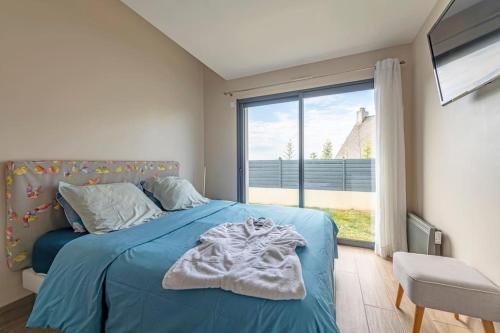 une chambre avec un lit bleu et une grande fenêtre dans l'établissement Rêve d'Océan Villa vue mer avec Piscine et Spa, au Conquet