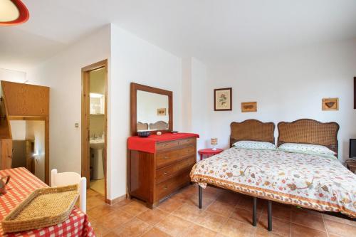 a bedroom with a bed and a dresser and a mirror at Appartamenti Larice Pila in Pila