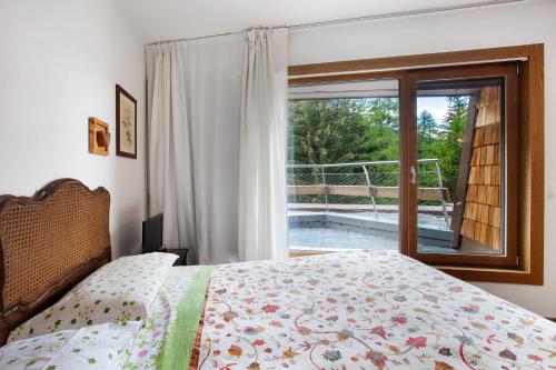 a bedroom with a bed and a large window at Appartamenti Larice Pila in Pila