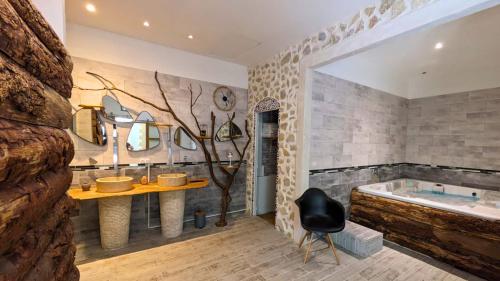 a bathroom with a tub and a table and a chair at Loft entre vignes et truffes - Gite en Provence Vaucluse in Valréas