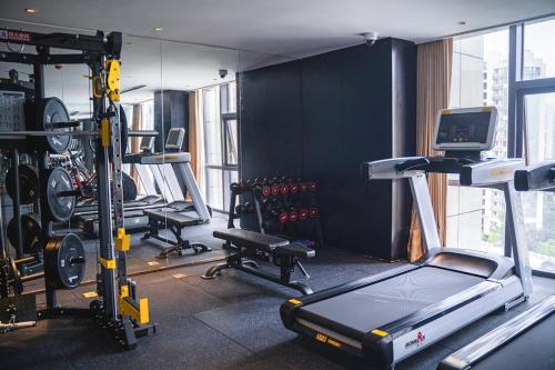 a gym with a treadmill and exercise equipment in it at Shanghai Maybeours Hotel in Fengxian