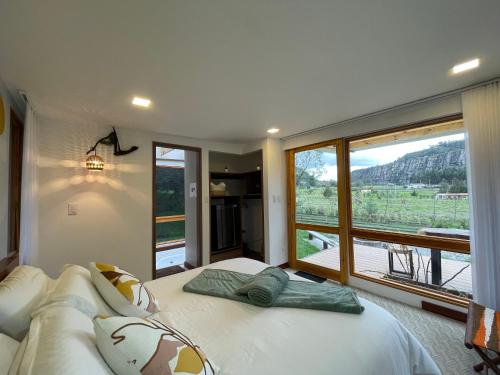 sypialnia z dużym łóżkiem i dużym oknem w obiekcie Casa del Oro w mieście Suesca
