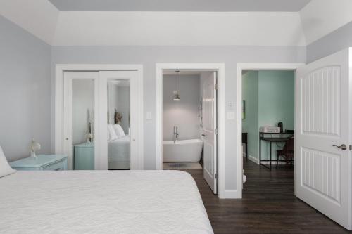 a white bedroom with a bed and a bathroom at Voyage Anchor in Nags Head