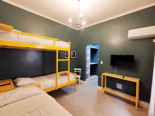 Hotel Windsor Mendoza في ميندوزا: غرفة نوم بسريرين بطابقين وتلفزيون بشاشة مسطحة