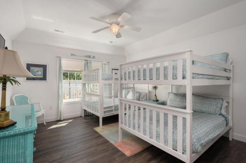 a room with two bunk beds and a ceiling fan at Voyage Anchor in Nags Head