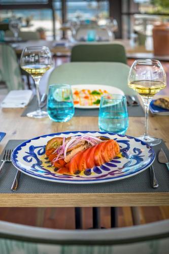a plate of food on a table with glasses of wine at Barceló Tenerife in San Miguel de Abona