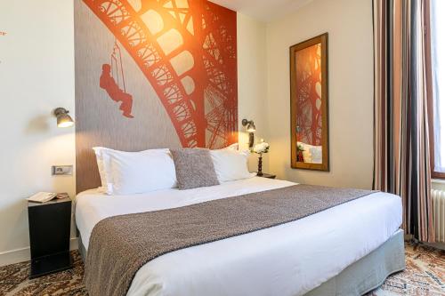 a bedroom with a large bed in a room at Hotel Alpha Paris Eiffel by Patrick Hayat in Boulogne-Billancourt