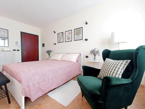 a bedroom with a bed and a green chair at La Casina in Sassari