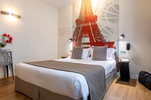 a bedroom with a large bed with a christmas tree on the wall at Hotel Alpha Paris Eiffel by Patrick Hayat in Boulogne-Billancourt