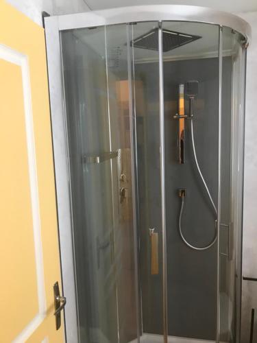 a shower with a glass door in a bathroom at Hotel Couleurs Sud Centre-ville Gare Charleville-Mézières in Charleville-Mézières