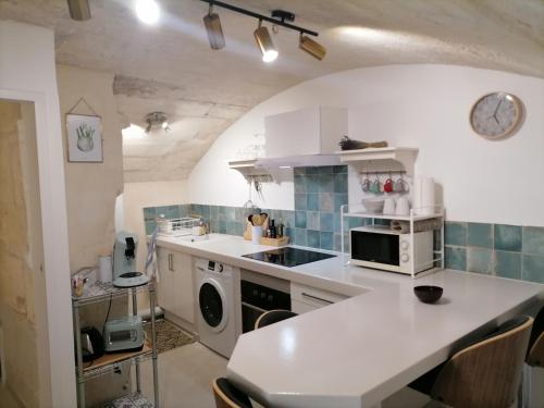 une cuisine avec un évier et une cuisinière four supérieur dans l'établissement Studio de charme au cœur d'Arles, à Arles