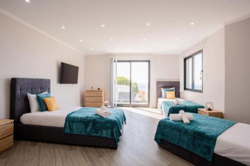 a bedroom with two beds and a large window at Pena View Villa in Santa Cruz